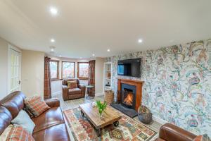 a living room with a couch and a fireplace at Gardener’s Cottage with Hot Tub in Blairgowrie