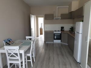 a kitchen with a table and a white refrigerator at Chill House Apartman Eger in Eger
