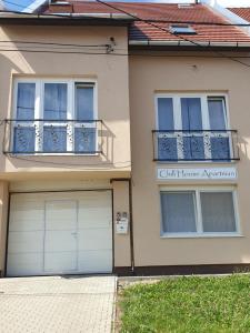 a house with two garage doors and a balcony at Chill House Apartman Eger in Eger
