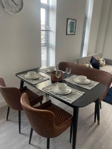 a dining room table with two chairs and a table with dishes on it at Kingdom apartments in Wolverhampton