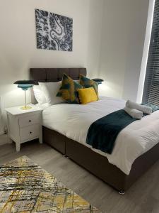 a bedroom with a large bed with yellow pillows at Kingdom apartments in Wolverhampton