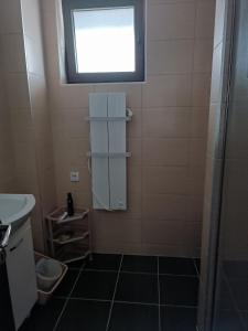 a small bathroom with a window and a sink at Zlatibor apartman Boki in Ocka Gora