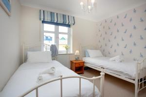 two beds in a bedroom with blue butterflies on the wall at Beacon House in Exmouth