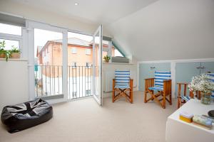 sala de estar con balcón con sillas y mesa en Beacon House, en Exmouth