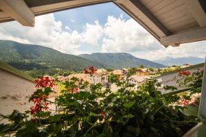 a view of a town from a balcony with flowers at Attico in centro a Folgaria in Folgaria