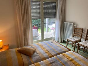 a bedroom with a bed and a large window at Appartements Gloeser in Badenweiler