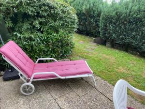 a pink couch on a cart in a garden at Appartements Gloeser in Badenweiler