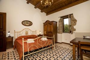 1 dormitorio con cama, mesa y ventana en Arcaloro Resort, en SantʼAngelo di Brolo