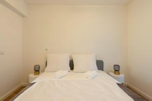 1 dormitorio con 1 cama blanca y 2 almohadas blancas en Designer Apartments, en Viena