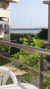 - Balcón con silla y vistas al agua en Appartement Plage Mehdia - Residence Kenz Mehdya Beach, en Kenitra