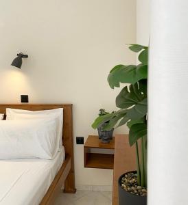 a bedroom with a bed and a potted plant at Villa Elva in Ammoudia