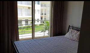 Un dormitorio con una cama y una ventana grande. en Appartement Plage Mehdia - Residence Kenz Mehdya Beach, en Kenitra 4 fotos más