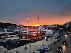 eine Gruppe von Booten, die bei Sonnenuntergang an einem Yachthafen angedockt sind in der Unterkunft PORT in Makarska