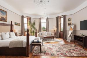 a bedroom with a bed and a living room at Tulloch Castle Hotel ‘A Bespoke Hotel’ in Dingwall
