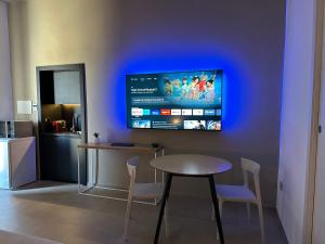 a kitchen with a table and a tv on a wall at MP Luxury room in Budoni