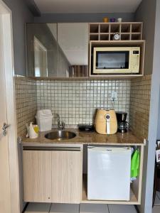 a small kitchen with a sink and a microwave at Flat no Condomínio Gran Lençóis-Barreirinhas - MA in Barreirinhas