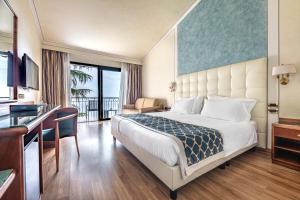 a hotel room with a bed and a desk at Hotel Villa Capri in Gardone Riviera