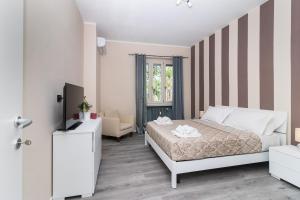 トリノにあるTrilocale con parcheggio privato Arena Inalpi, PalaTazzoli, Palavela Lingotto, "Exclusive Suite " La casa di Bertino "のベッドと椅子のある白い寝室