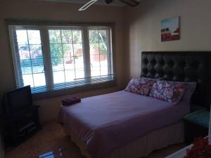 Un dormitorio con una cama grande y un televisor. en Mphesheleng Guesthouse, en Bela-Bela 17 fotos más