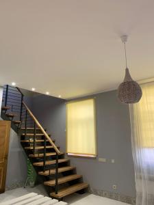 eine Treppe in einem Haus mit hängendem Licht in der Unterkunft Libau Apartment in Liepāja