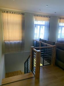 eine Treppe in einem Zimmer mit Fenstern in der Unterkunft Libau Apartment in Liepāja