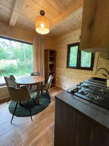 a kitchen with a table and a stove in a cabin at Villejka, domki i domy wakacyjne in Wetlina