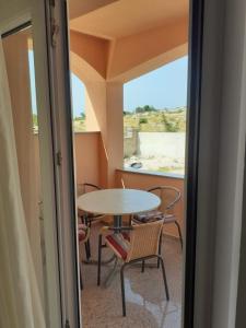 a room with a table and chairs and a window at Apartmani Drage in Drage