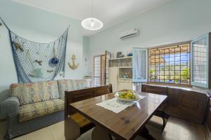 una sala da pranzo con un tavolo e un divano di Podere Le Palme a Castiadas