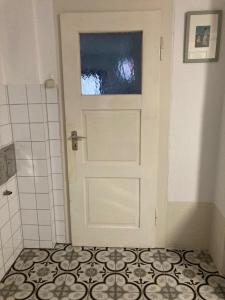 een witte deur in een badkamer met een tegelvloer bij Bauernhaus in der Bayrischen Rhön in Schönau an der Brend