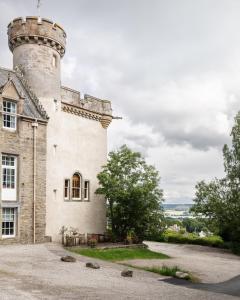 a building with a tower on top of it at Tulloch Castle Hotel ‘A Bespoke Hotel’ in Dingwall