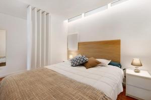 sypialnia z dużym łóżkiem z drewnianym zagłówkiem w obiekcie Estoril Art and Surf w mieście Estoril