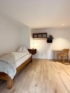 1 dormitorio con 1 cama y suelo de madera en Hotel Rätia, en Ilanz