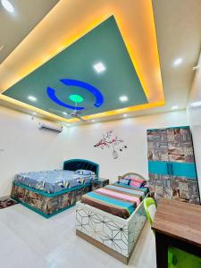 two beds in a room with a large ceiling at Smart Stays in Gorakhpur