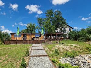 a log home with a porch and a house at Pensiunea Bella Vista in Turda
