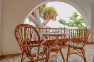アガエテにあるLovely house views&gardenの木のあるバルコニー(椅子2脚、テーブル1台付)