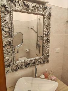 bagno con specchio e lavandino di B&B RESIDENZA DUCALE a Taviano