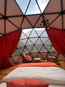 ein Schlafzimmer in einem Zelt mit einem Bett und einem Fenster in der Unterkunft Siya dome & glamping in Çamlıhemşin
