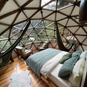 a bedroom with a bed in a yurt with windows at Siya dome & glamping in Çamlıhemşin