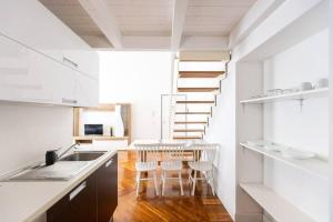 eine Küche mit einer Treppe, einem Tisch und Stühlen in der Unterkunft Loft2 via morosini centro Varese - Ixihome in Varese