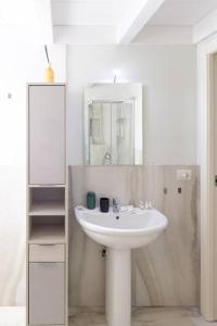ein weißes Badezimmer mit einem Waschbecken und einem Spiegel in der Unterkunft Loft2 via morosini centro Varese - Ixihome in Varese
