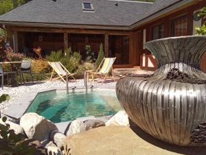 a pool with chairs and a fountain in front of a house at L' Auberge du château in Génos