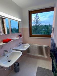 a bathroom with two sinks and a window at Ferienwohnung Schwarzwald Oase Kniebis in Kniebis