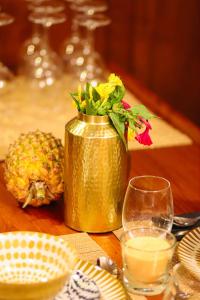 a gold vase with a flower in it on a table at Alejandro Magno in Ponta Delgada