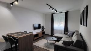 ein Wohnzimmer mit einem Sofa und einem Tisch in der Unterkunft Apartments Spring in Čačak