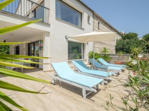 patio con sedie a sdraio blu e ombrellone di Finca Son Baulo a Can Picafort