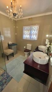 a large bathroom with a sink and a toilet at Peace Lily Garden Cottage in George