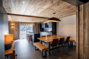uma cozinha e sala de jantar com uma mesa de madeira e cadeiras em Appartement Les Myrtilles - pied des pistes - 10 personnes em Les Deux Alpes