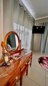 a dressing table with a mirror on top of it at Peace Lily Garden Cottage in George