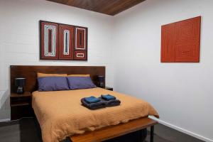 a bedroom with a bed with two towels on it at 4 Bedrooms, 2 Bathrooms in Alice Springs in Alice Springs