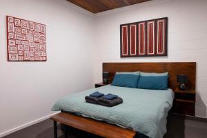 ein Schlafzimmer mit einem Bett mit zwei Handtüchern darauf in der Unterkunft 4 Bedrooms, 2 Bathrooms in Alice Springs in Alice Springs